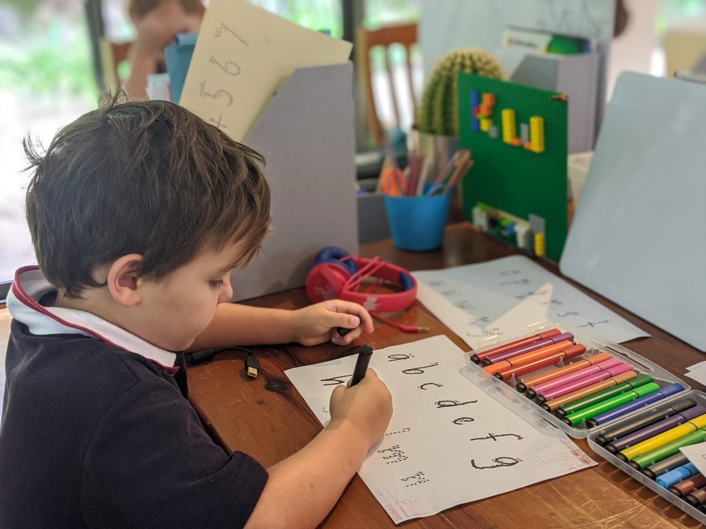 Young boy practicing letter formation 